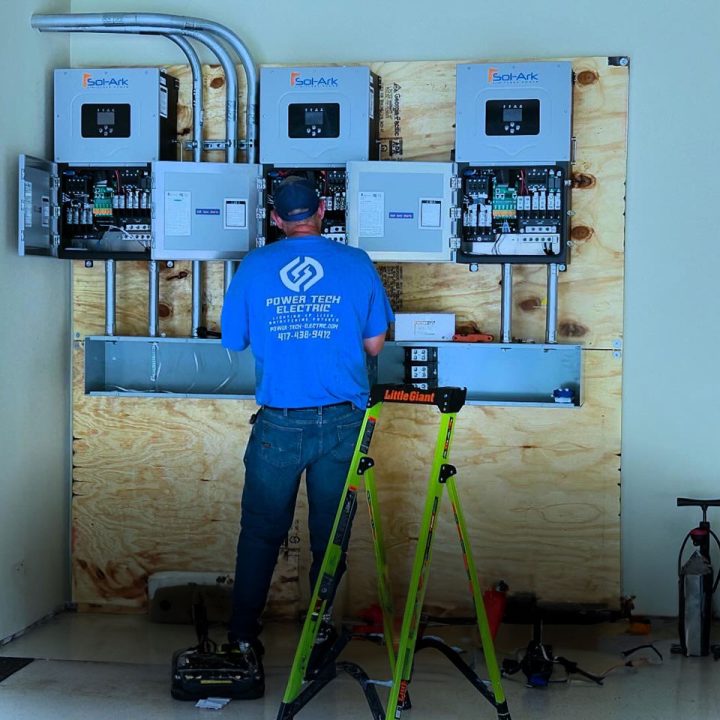 An electrician working on a solar panel system and electrical equipment inside a home, showcasing professional installation services.